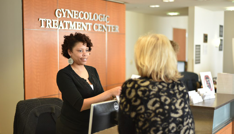A desk attendant helps a woman at the Gynecologic Treatment Center