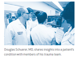 Douglas Schuerer, MD, shares insights into a patient's condition with members of his trauma team.