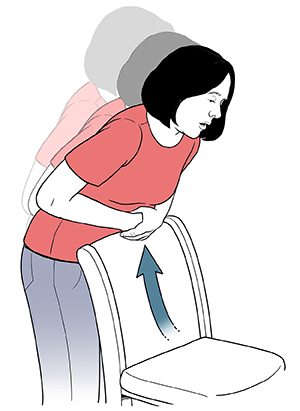 Woman bending over the back of a chair to perform choking self-rescue.