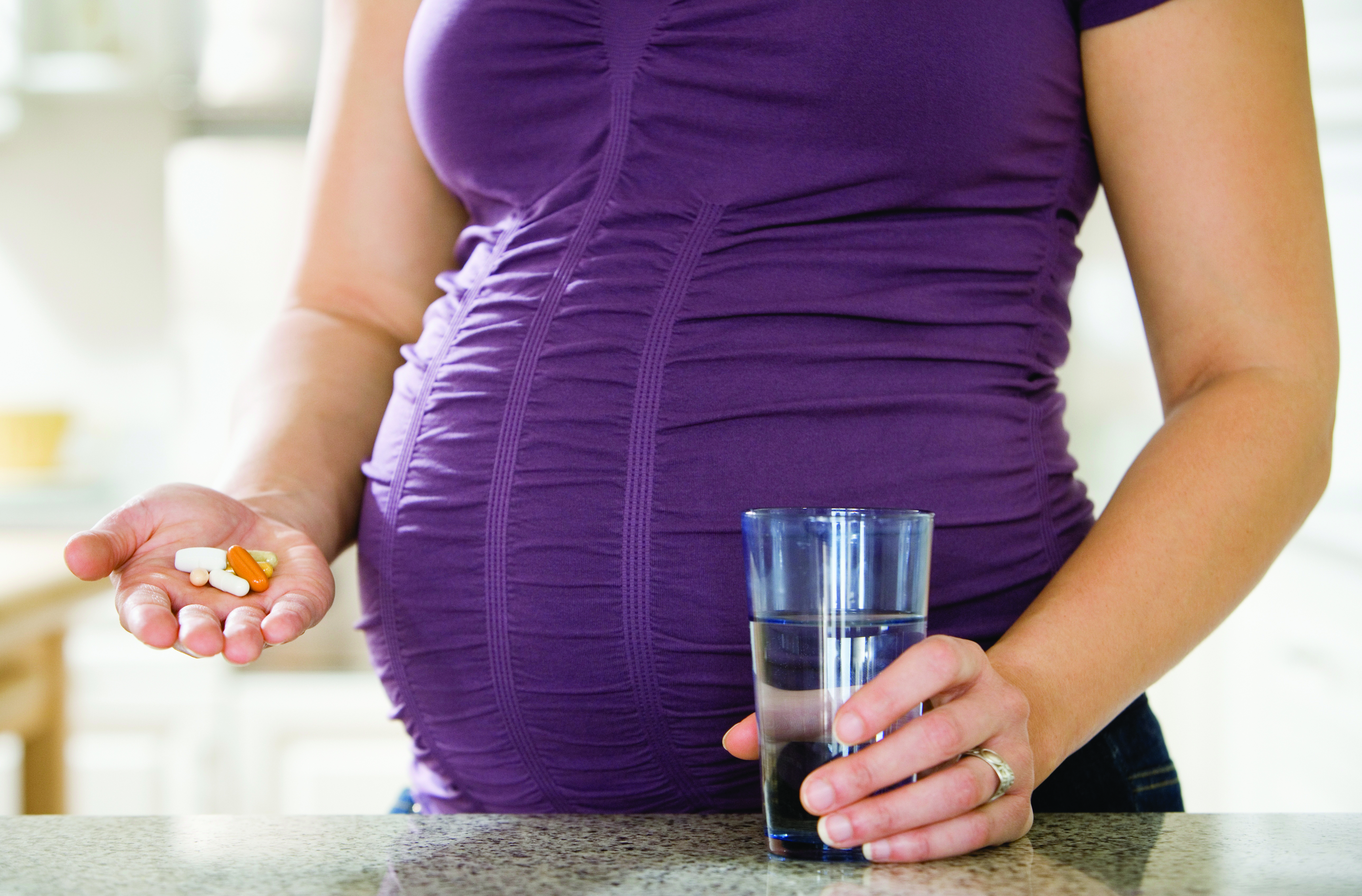 A pregnant woman holds a handful of pills - Opioid Use in Pregnancy clinic A pregnant woman holds a handful of pills - Opioid Use in Pregnancy clinic
