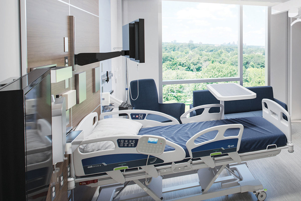 photo of a patient room in a hospital with green trees outside the window.