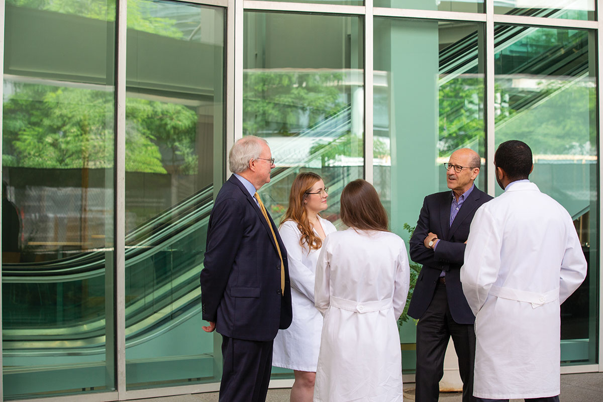 John lynch, MD, (far left) and David Perlmutter, MD, (second from right) with urology and general surgery residents, and a cardiology fellow - Treat, Research, Educate,
Repeat: Inside Academic Medicine’s Virtuous Cycle