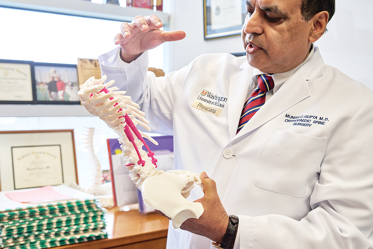 Munish Gupta, MD, uses a 3D model of a patient’s spine as an aid in planning surgery.