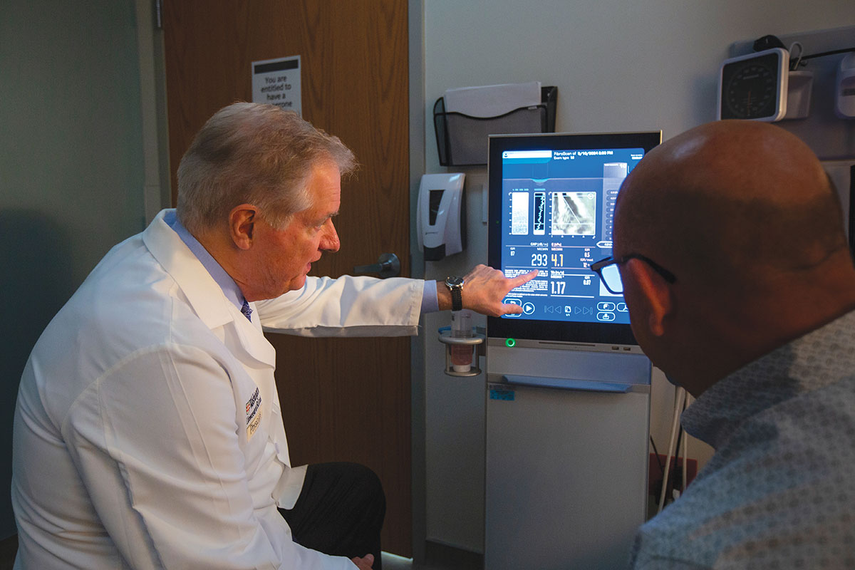 Jeffrey Crippin, MD, gastroenterologist and hepatologist, discusses treatment options with a patient.