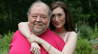 A father and daughter smile at the camera