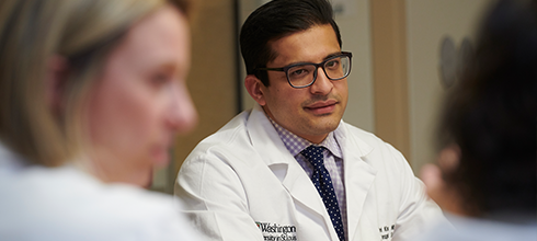 A doctor talks with his team. A doctor talks with his team