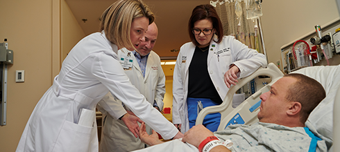 A team of physicians meets with a kidney transplant patient