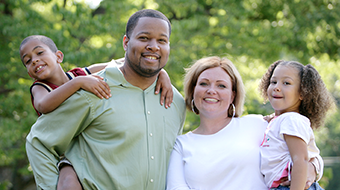 A family smiles at the camera