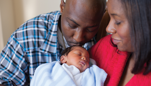 A mother and father dote on their newborn