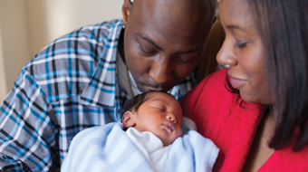 A mother and father dote on their newborn