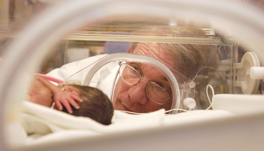 A physician checks on an infant in the NICU