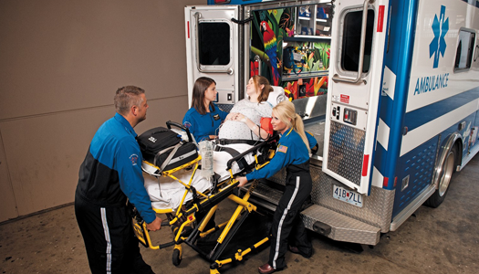 Maternal-Fetal Transport team loads a high-risk pregnant woman into the ambulance