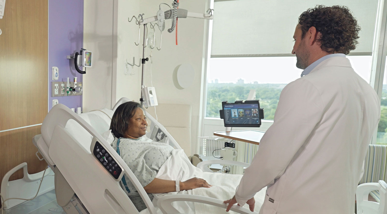 Doctor speaking to a patient laying in a hospital bed