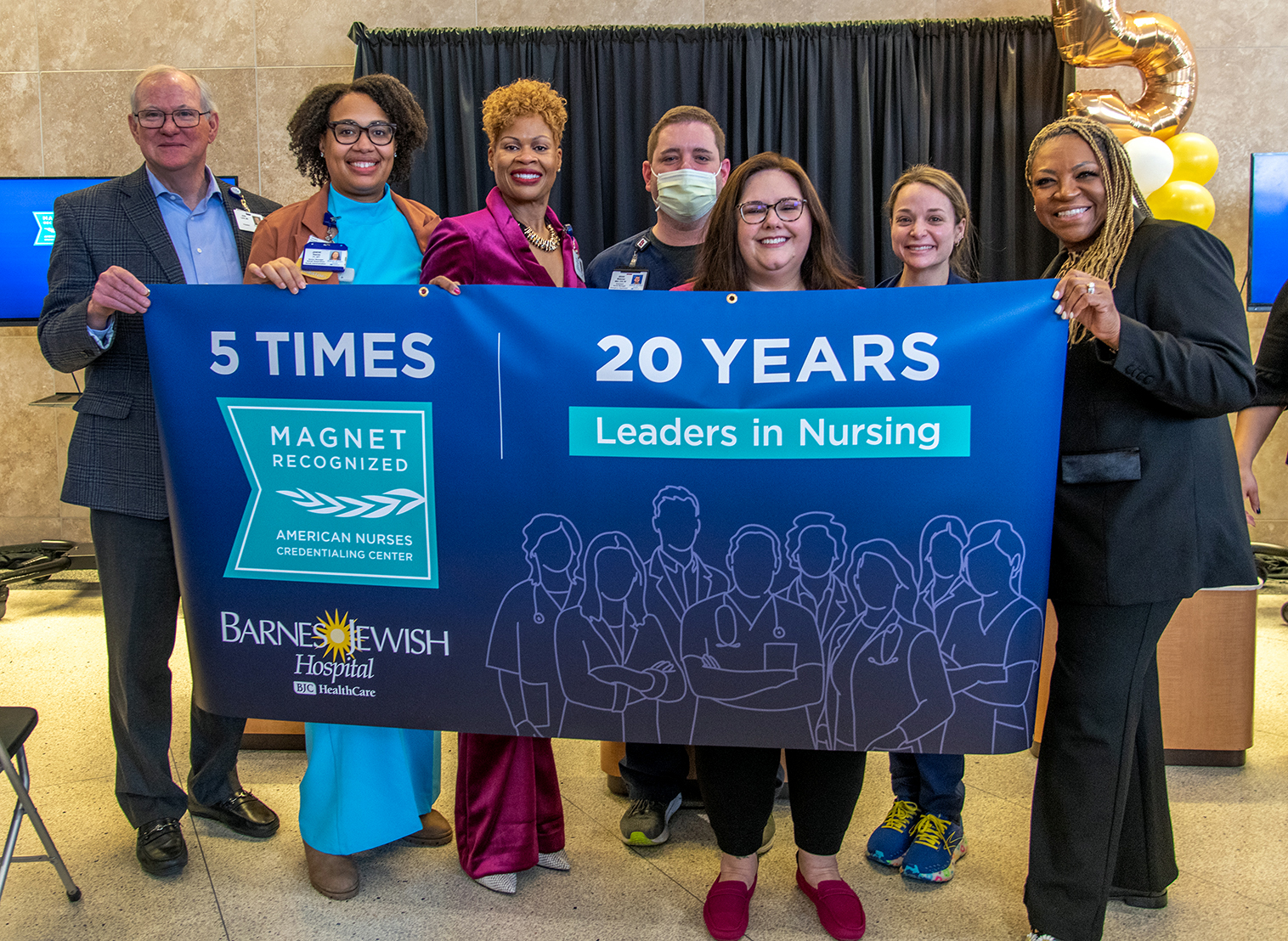 Nurses at Barnes-Jewish Hospital proudly holding an excellence in nursing banner